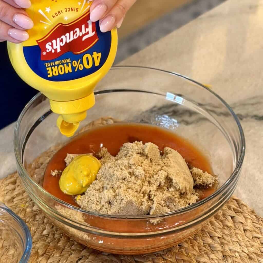 Mixing sauce for ham balls in a bowl.
