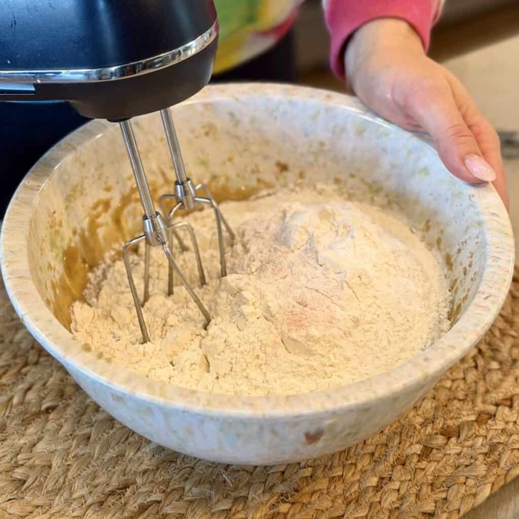 Mixing in flour with wet ingredients.