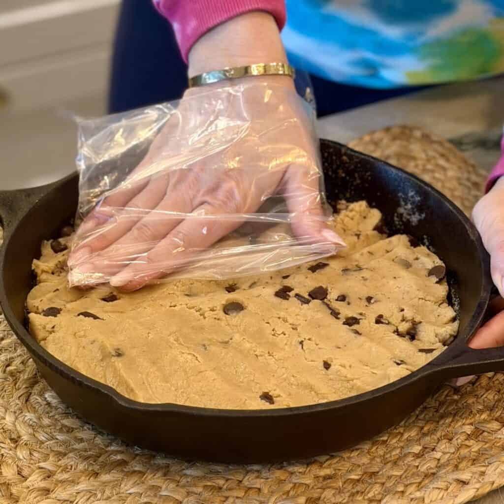 Patting dough mixture onto the skillet.