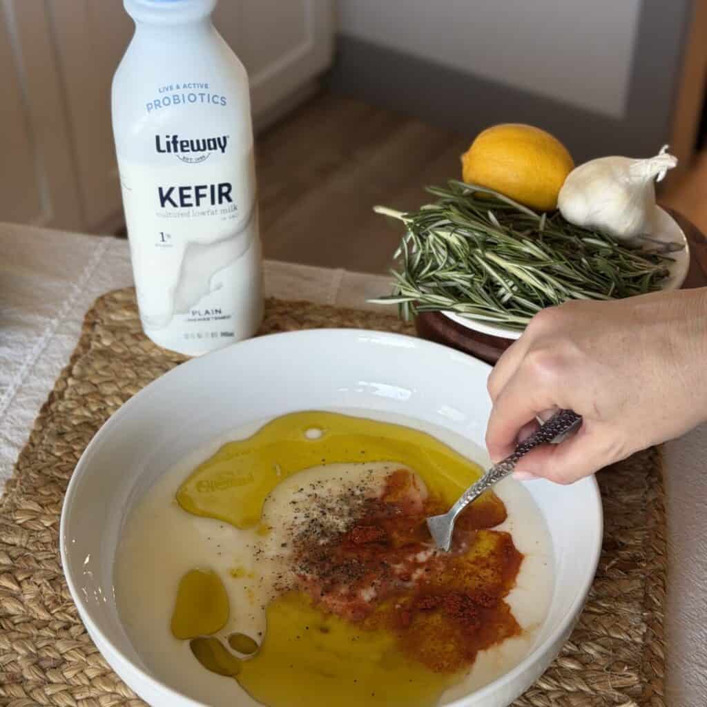 Whisking together a chicken marinade in a bowl.