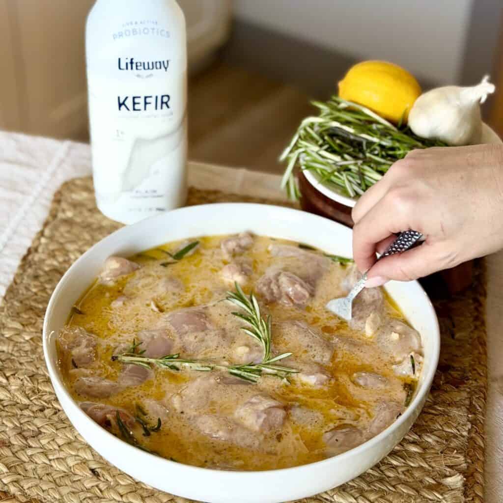 Putting chicken in a marinade.