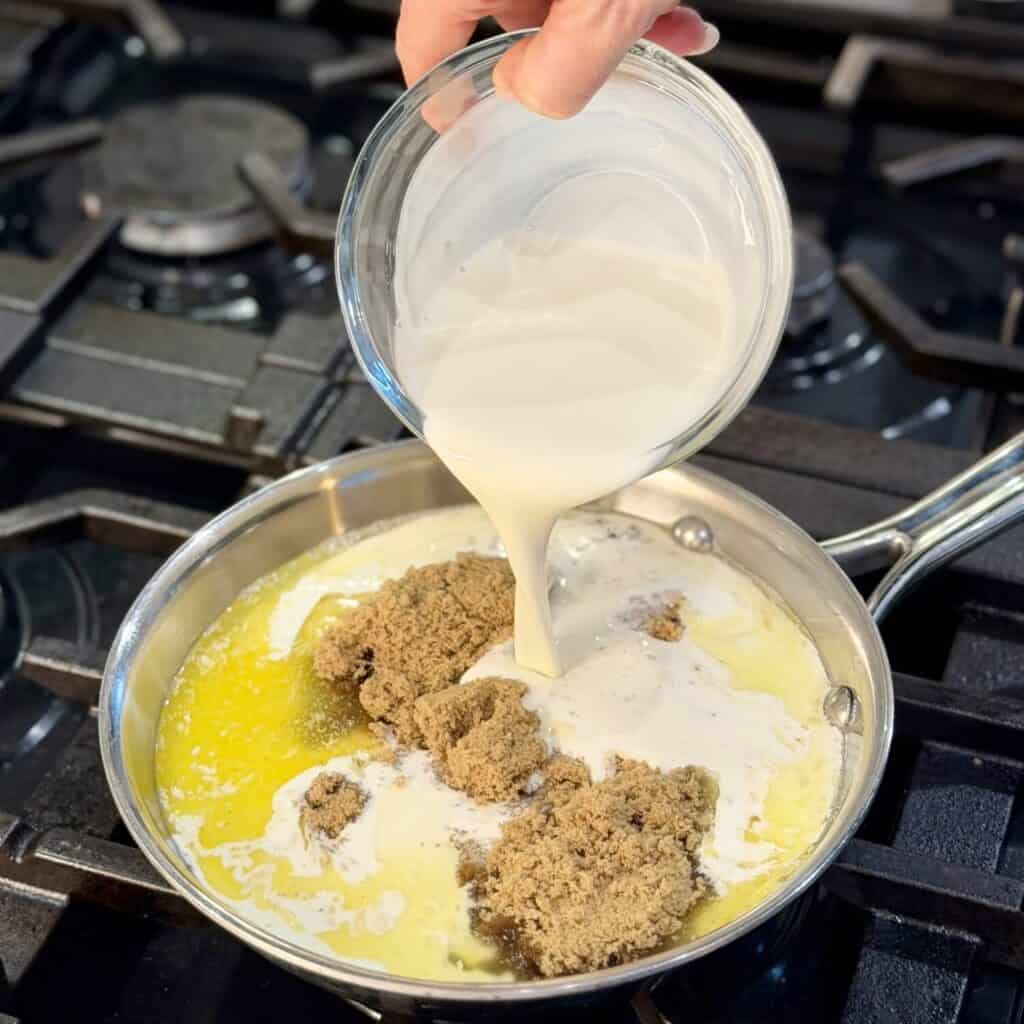 Whisking together the ingredients of brown sugar butter sauce in a pan.
