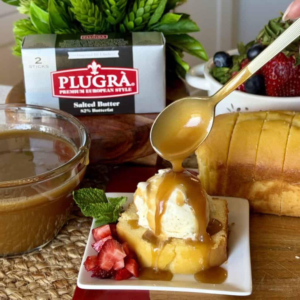 Brown sugar butter sauce being poured over cake.