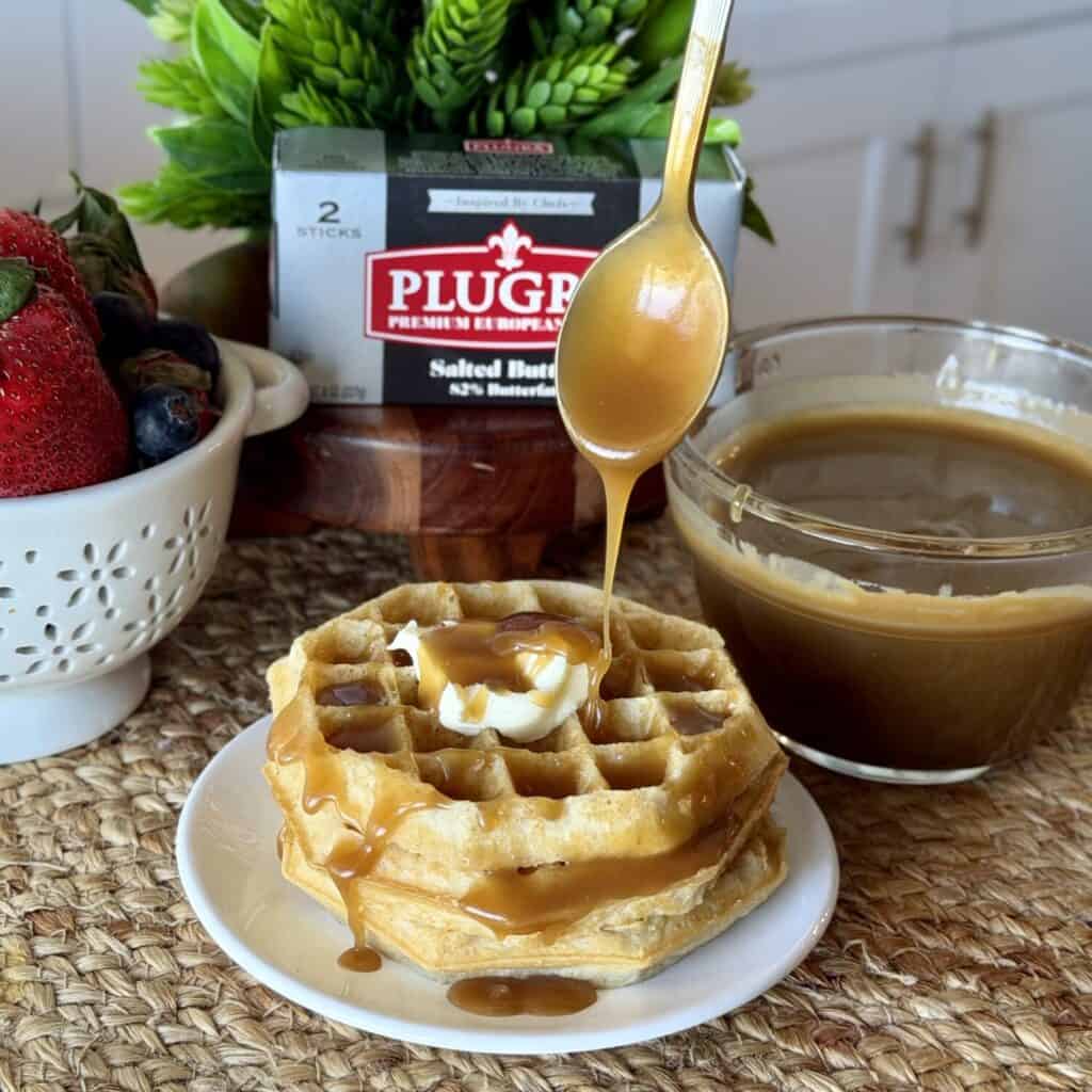 Brown sugar butter sauce being poured over waffles.