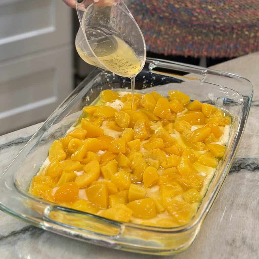 Adding peach juice to the dish.