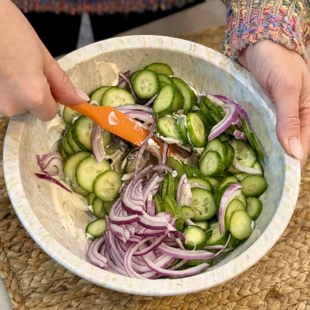 Mixing vegetables into bowl.