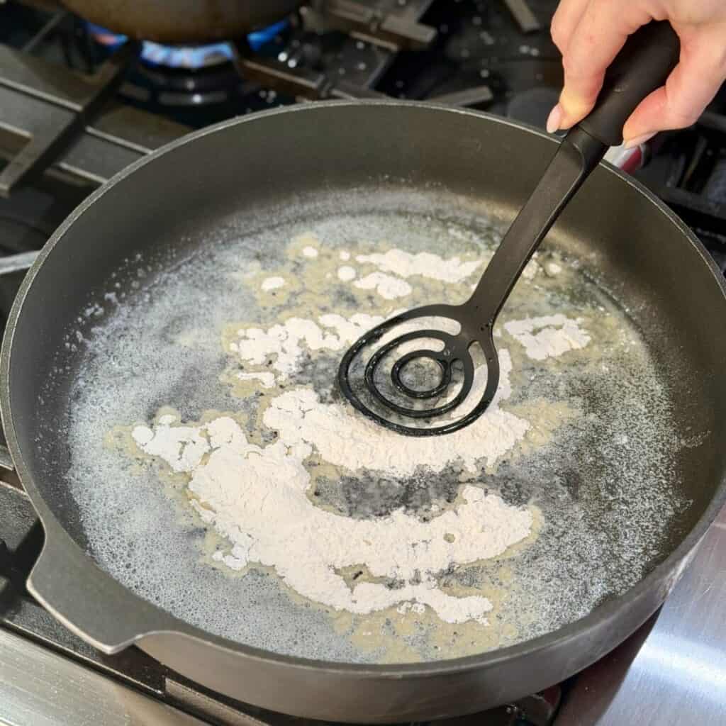 Mixing flour in for the sauce.