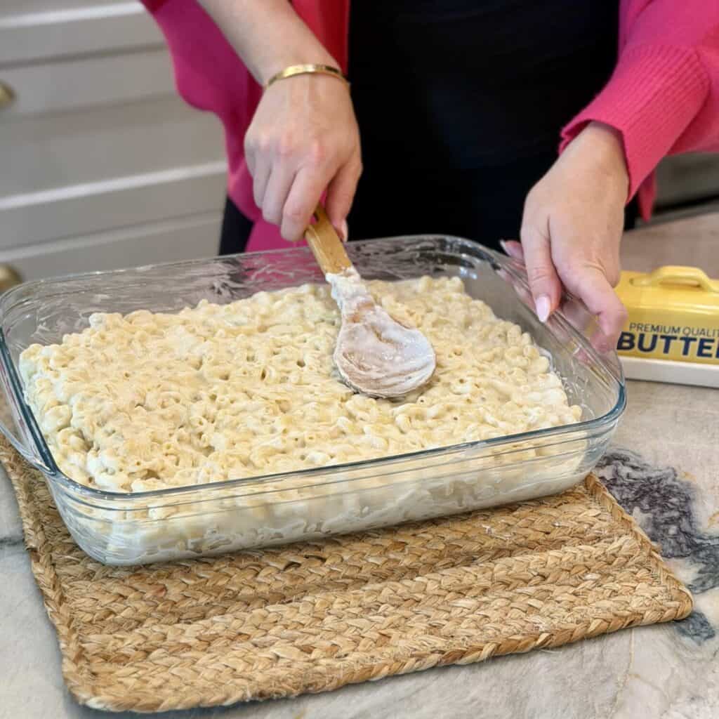 Spreading in Mac and cheese to the pan.