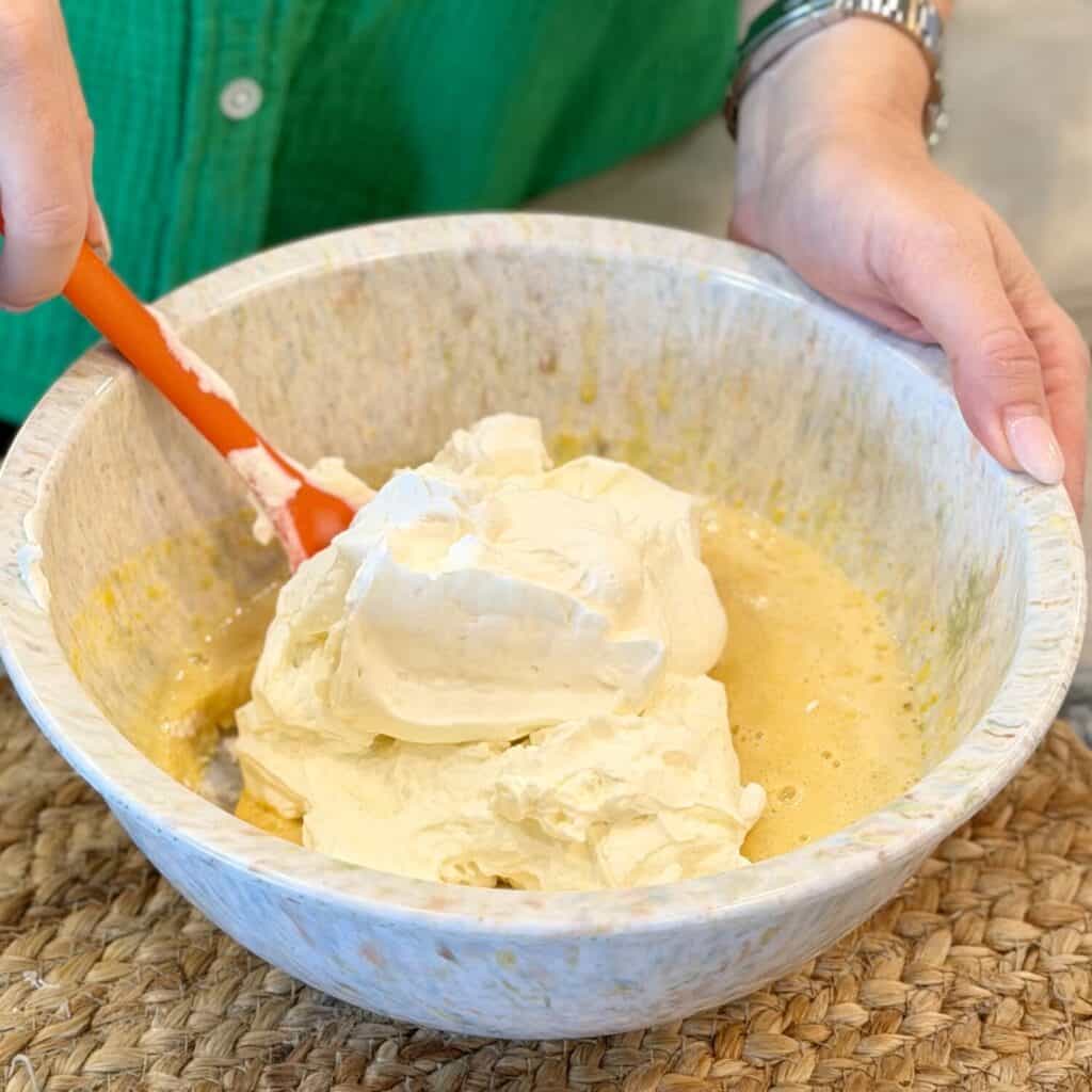 Adding cream cheese to the bowl.