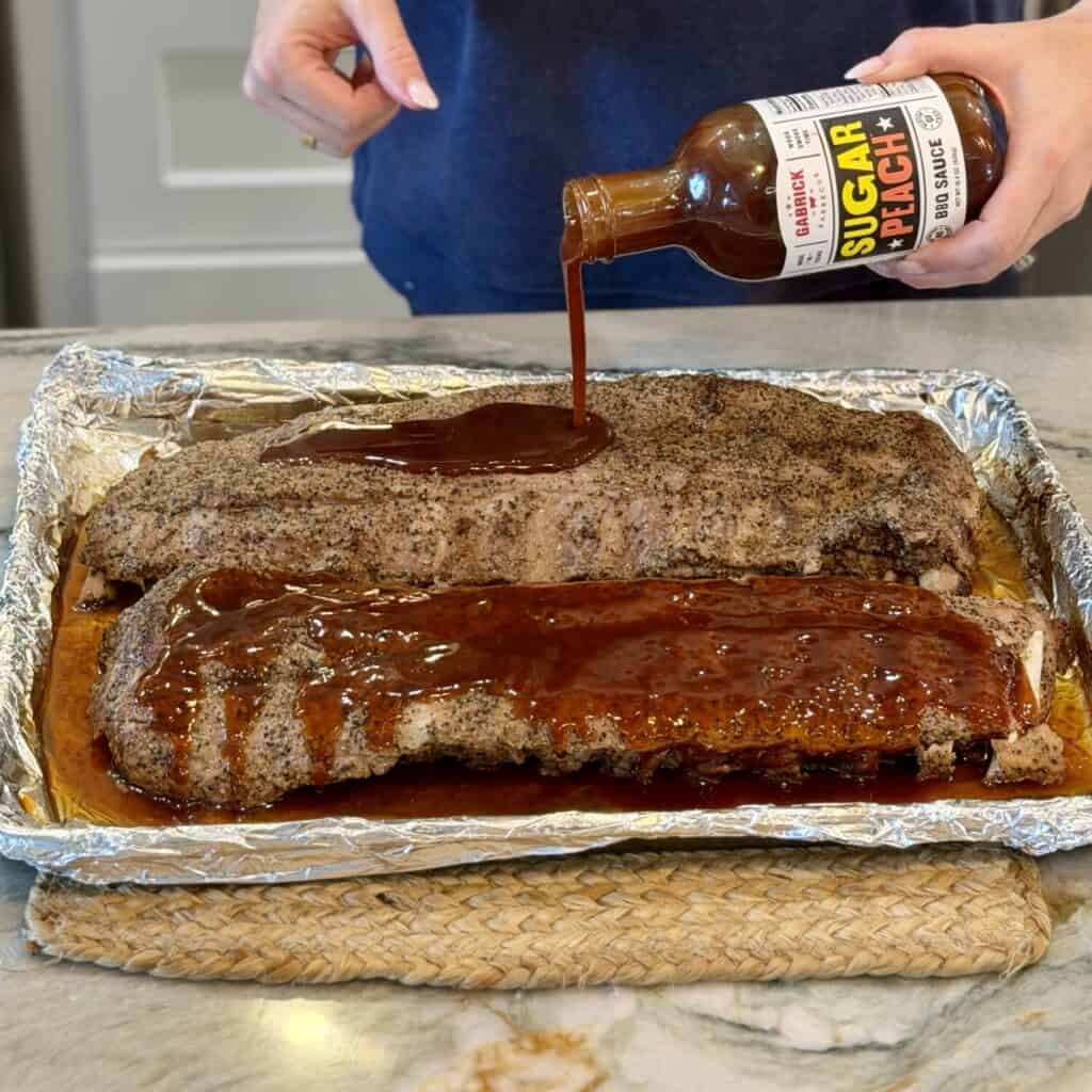 Adding Barbecue sauce to the ribs.