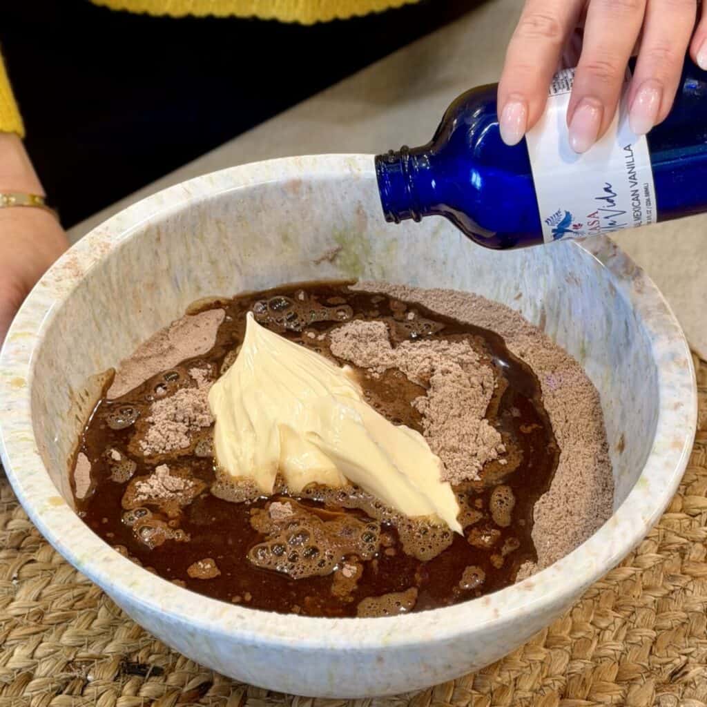 Adding vanilla extract to cake mixture.