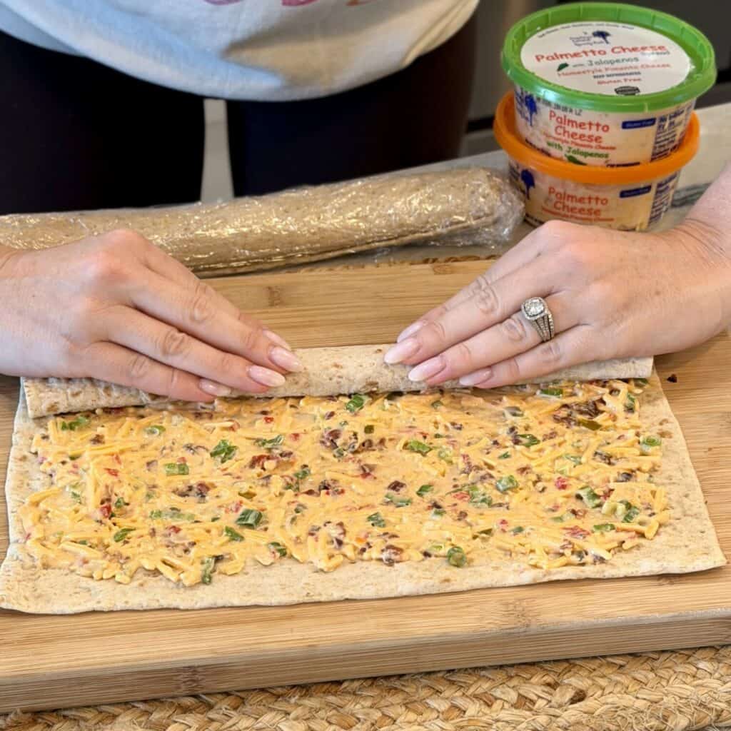 Rolling up pimento cheese pinwheels.