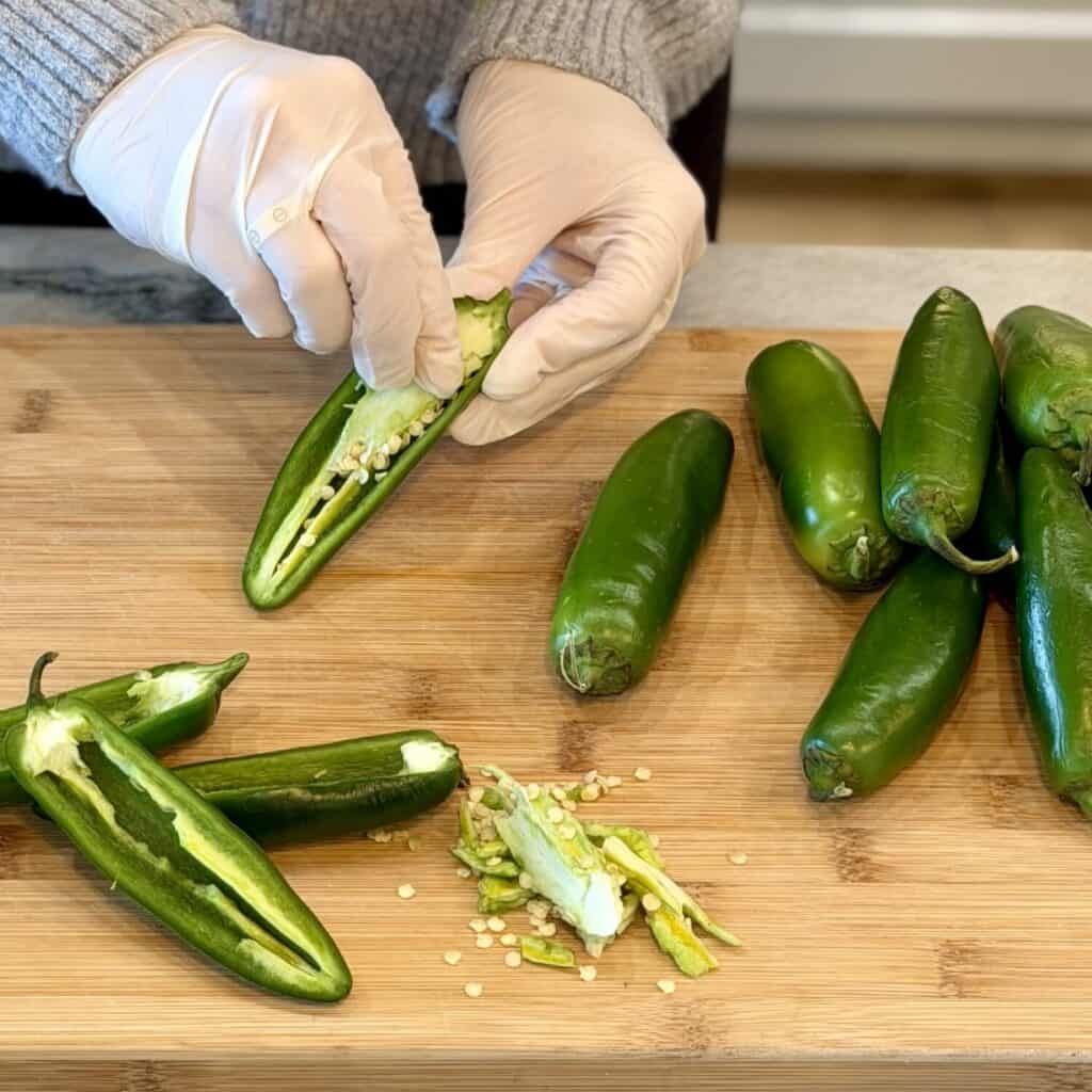 Taking all the seeds out of the jalapenos.
