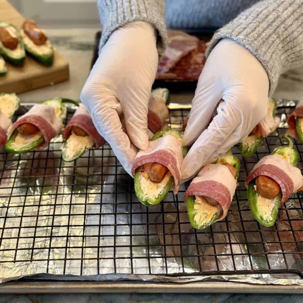 Setting the Bacon wrapped jalapeño poppers onto the rack.