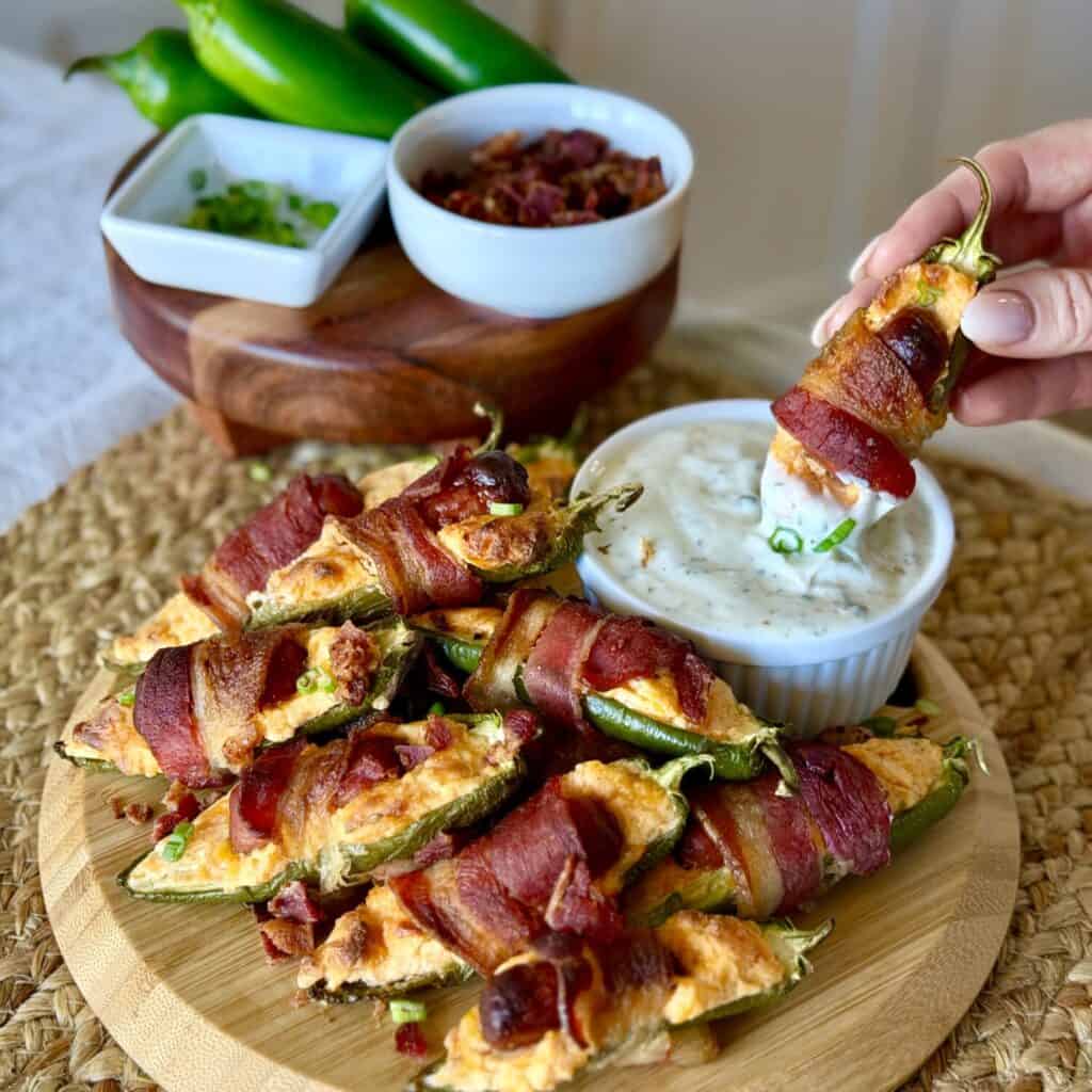 Dipping a Bacon wrapped jalapeño popper into the sauce.