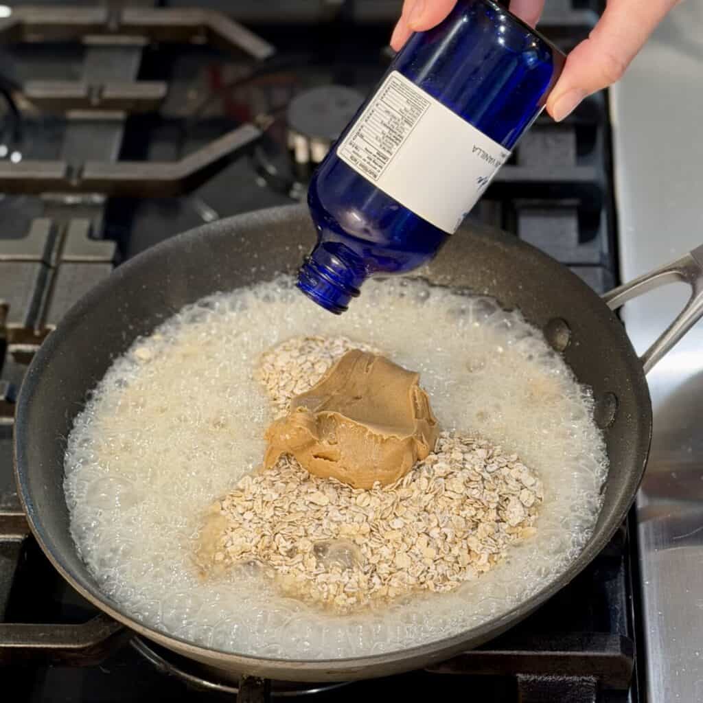 Adding vanilla extract to the pan.
