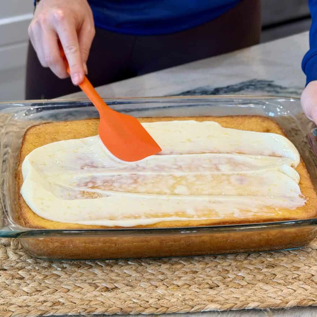 Adding lemon icing to the cake.