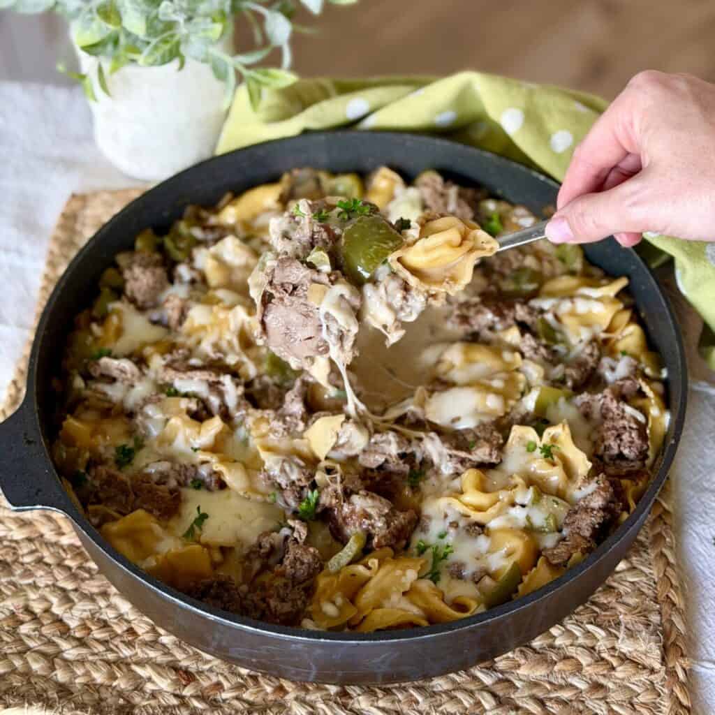 Holding a spoon of cheesesteak tortellini.