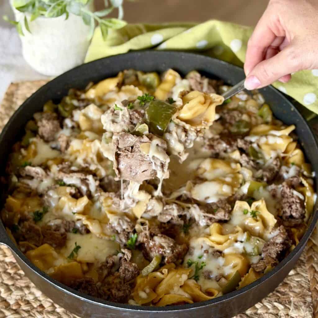 holding a spoon of cheesesteak tortellini.