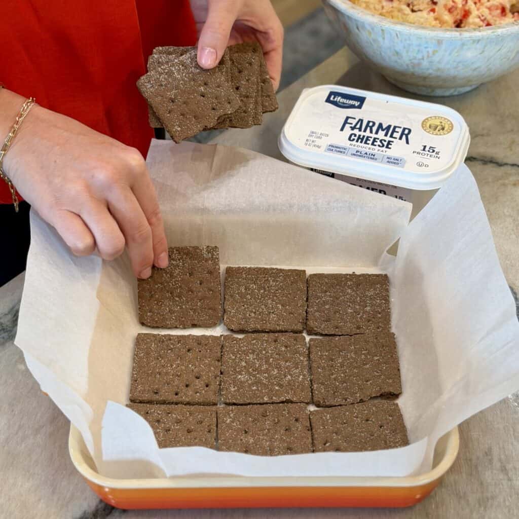 Laying crackers on the pan.