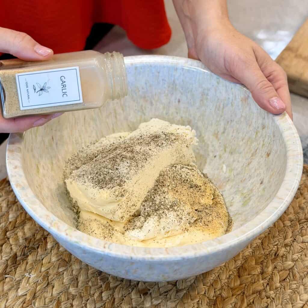 Adding garlic to cream cheese.