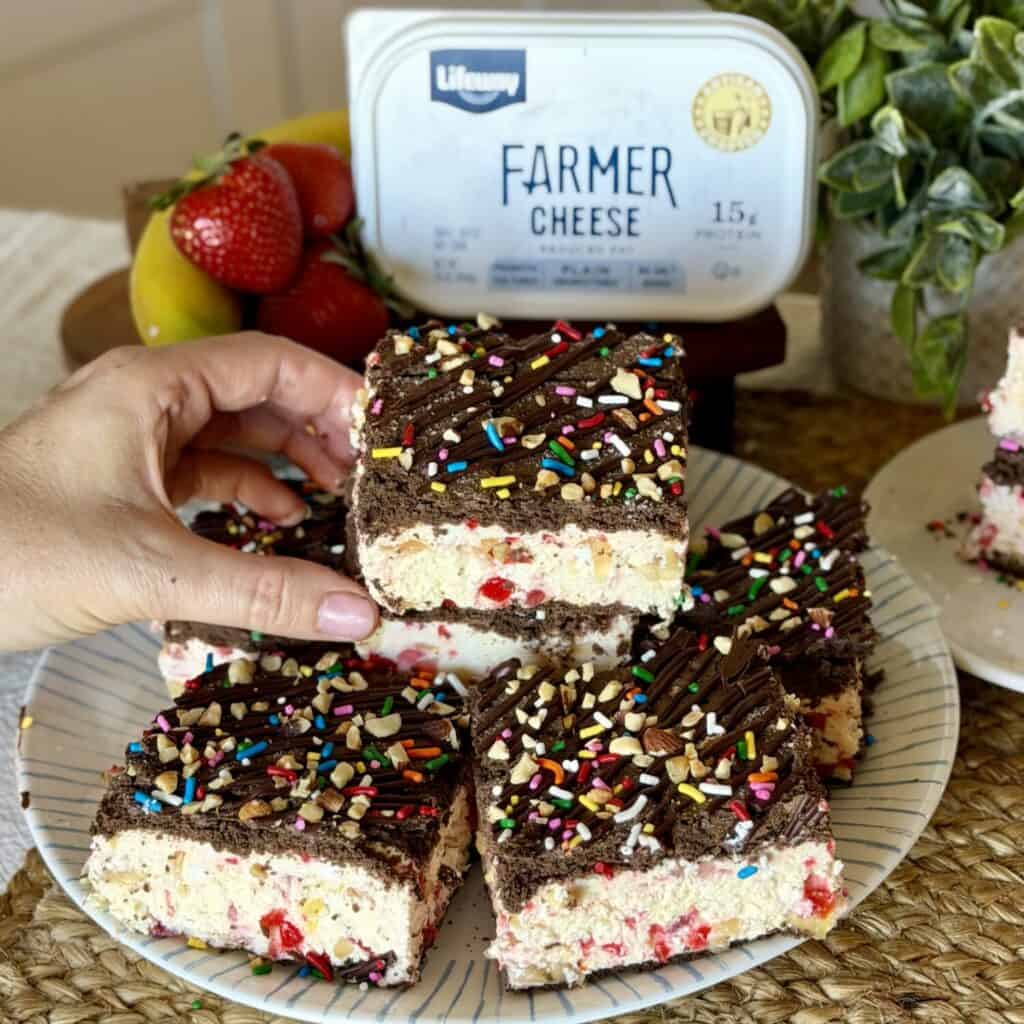 Holding a banana split ice cream sandwich.