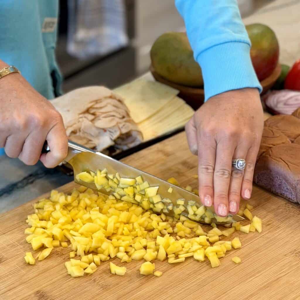 Dicing mango on a cutting board.