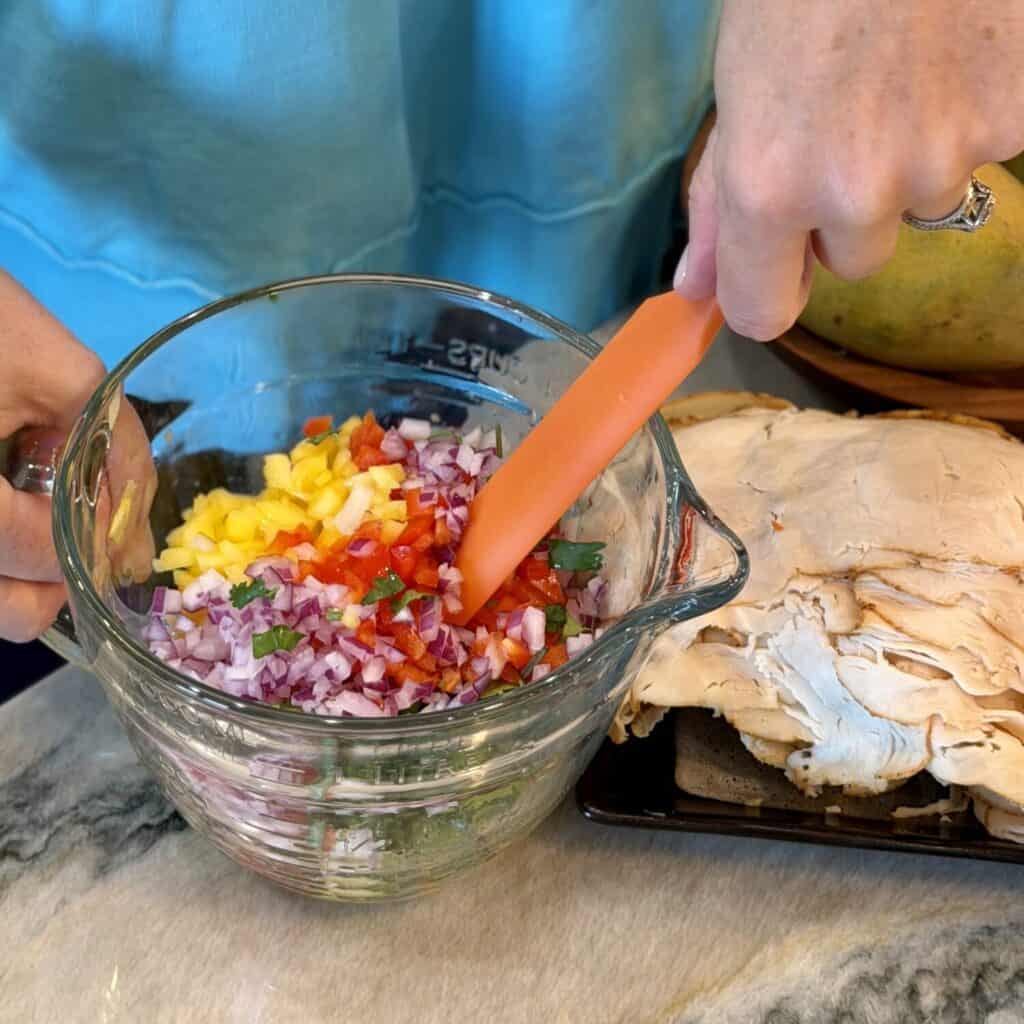Making a mango salsa in a bowl.