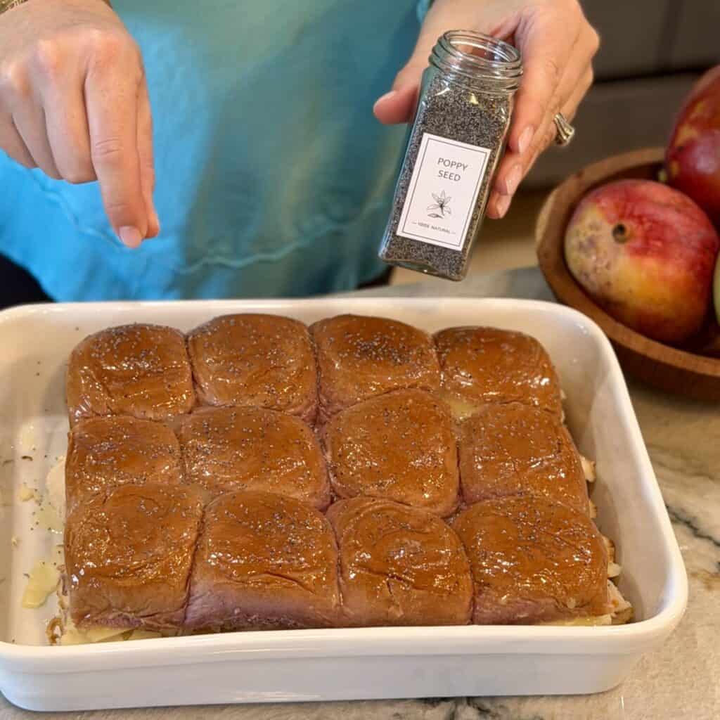 Sprinkling on poppyseeds on sliders.