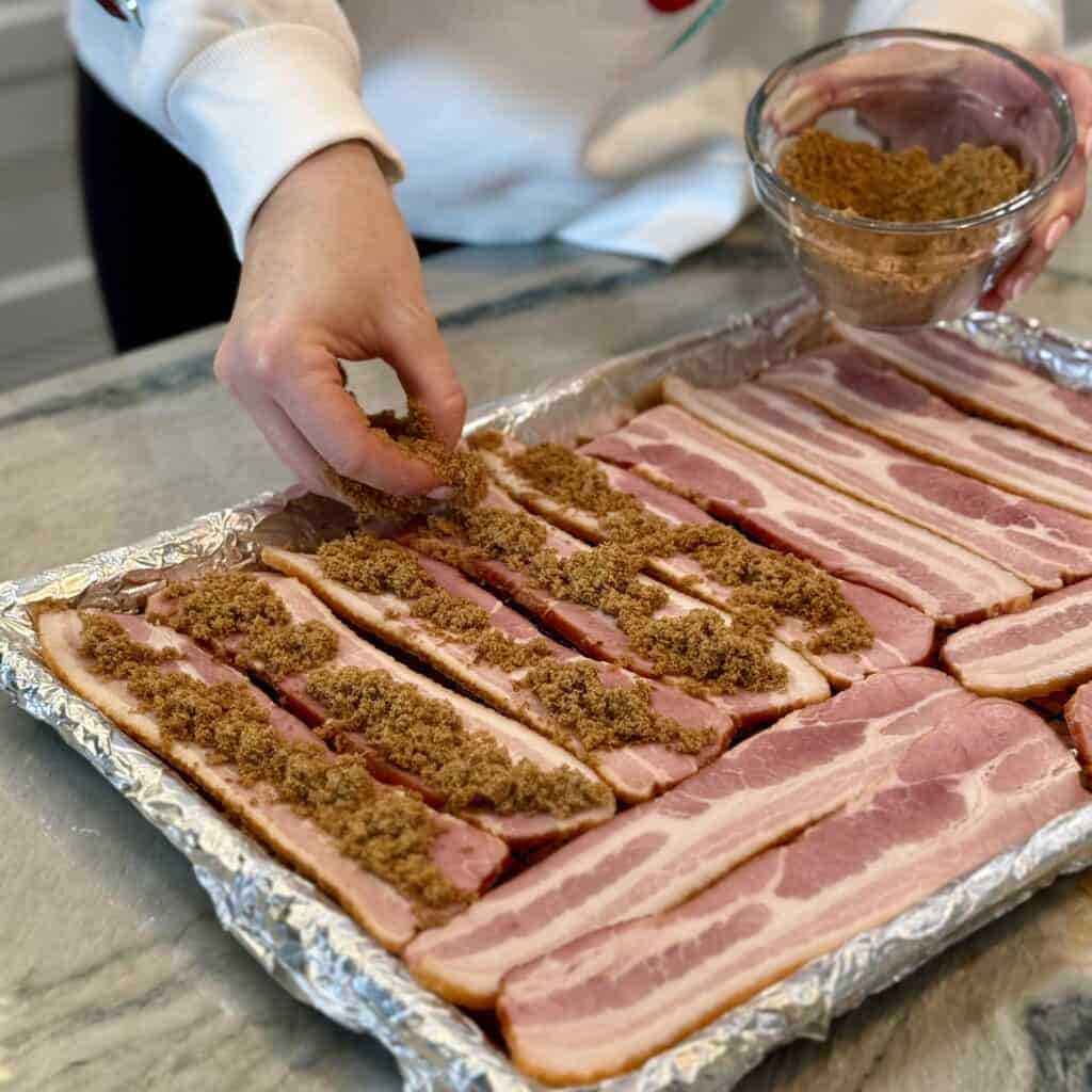 Adding seasoning onto the bacon.