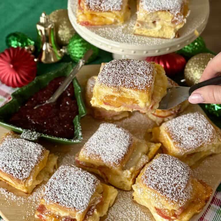 Adding powdered sugar to the Monte Cristo Sliders.