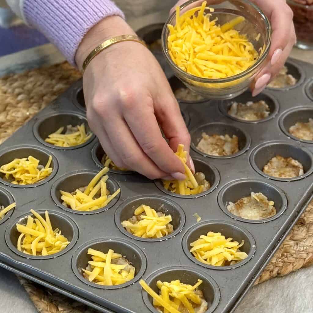 Adding cheese to the crispy rounds.