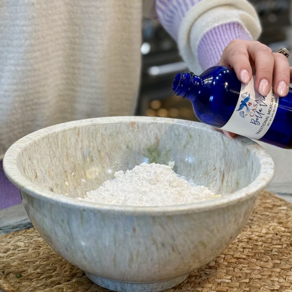 Adding vanilla extract to the powdered sugar.