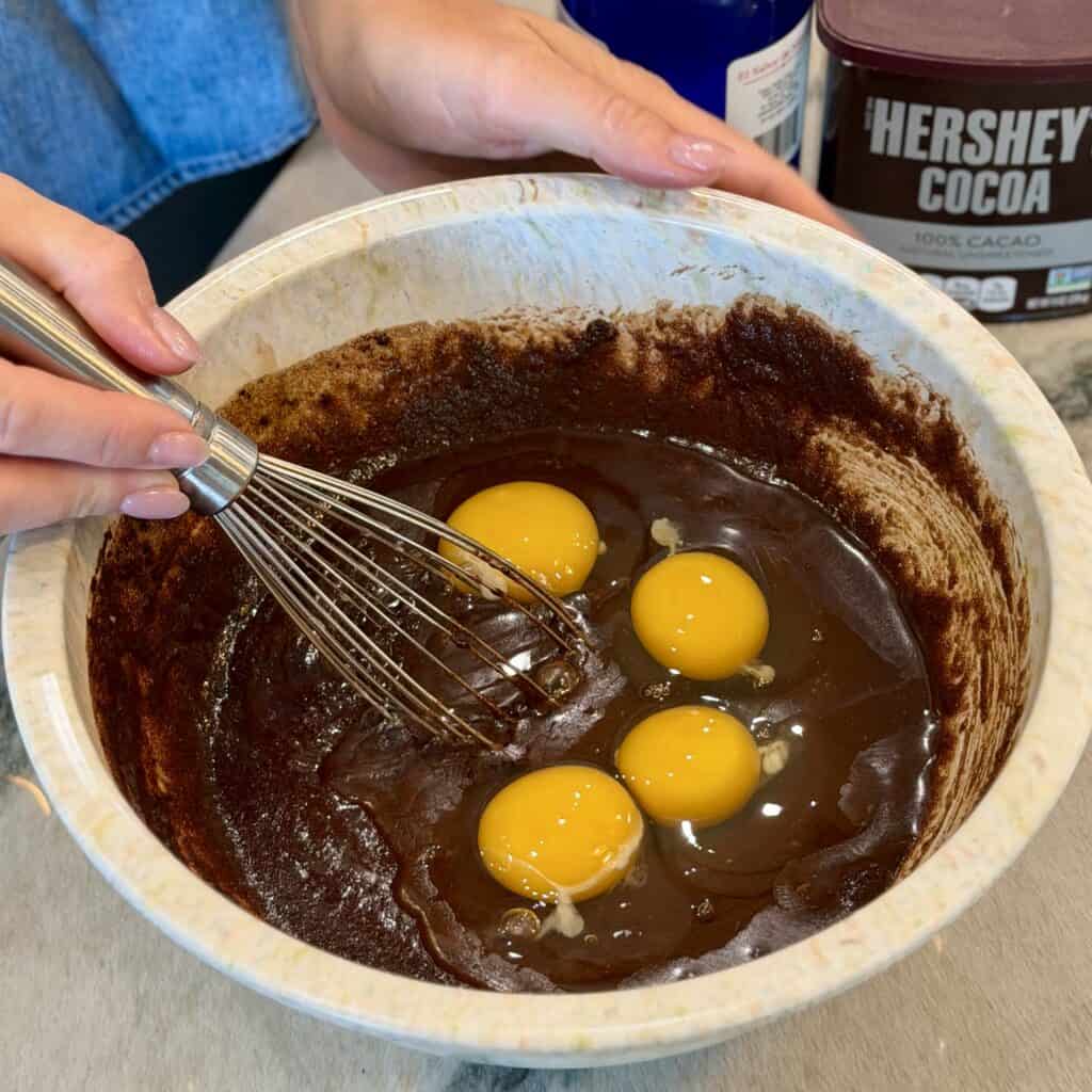 Adding eggs to the bowl.