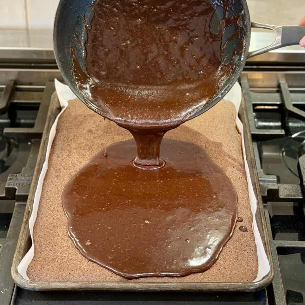 Adding chocolate sauce to the cake.