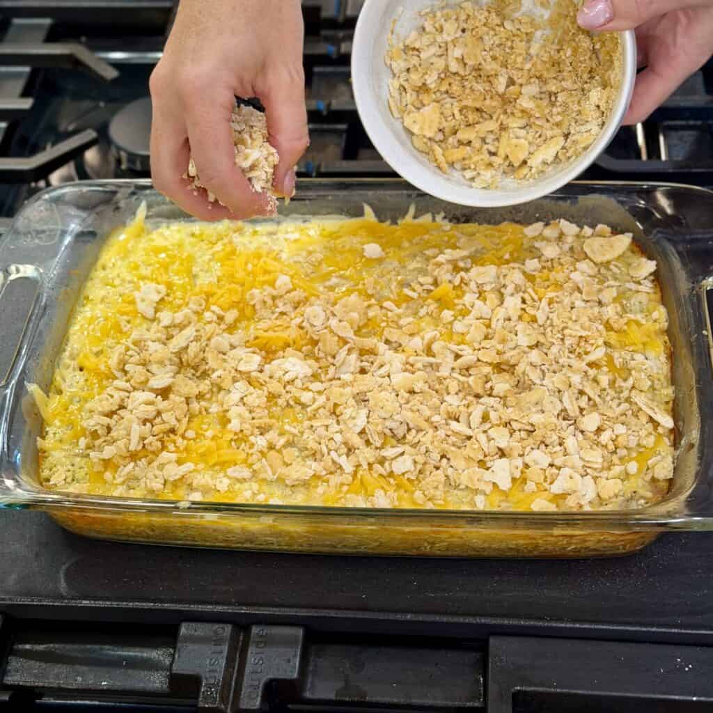 Adding crushed crackers to the pan.