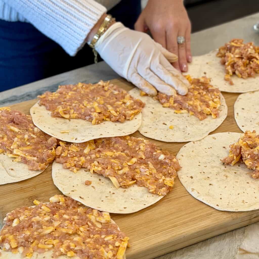 Adding meat mixture to the sheet pan taco.