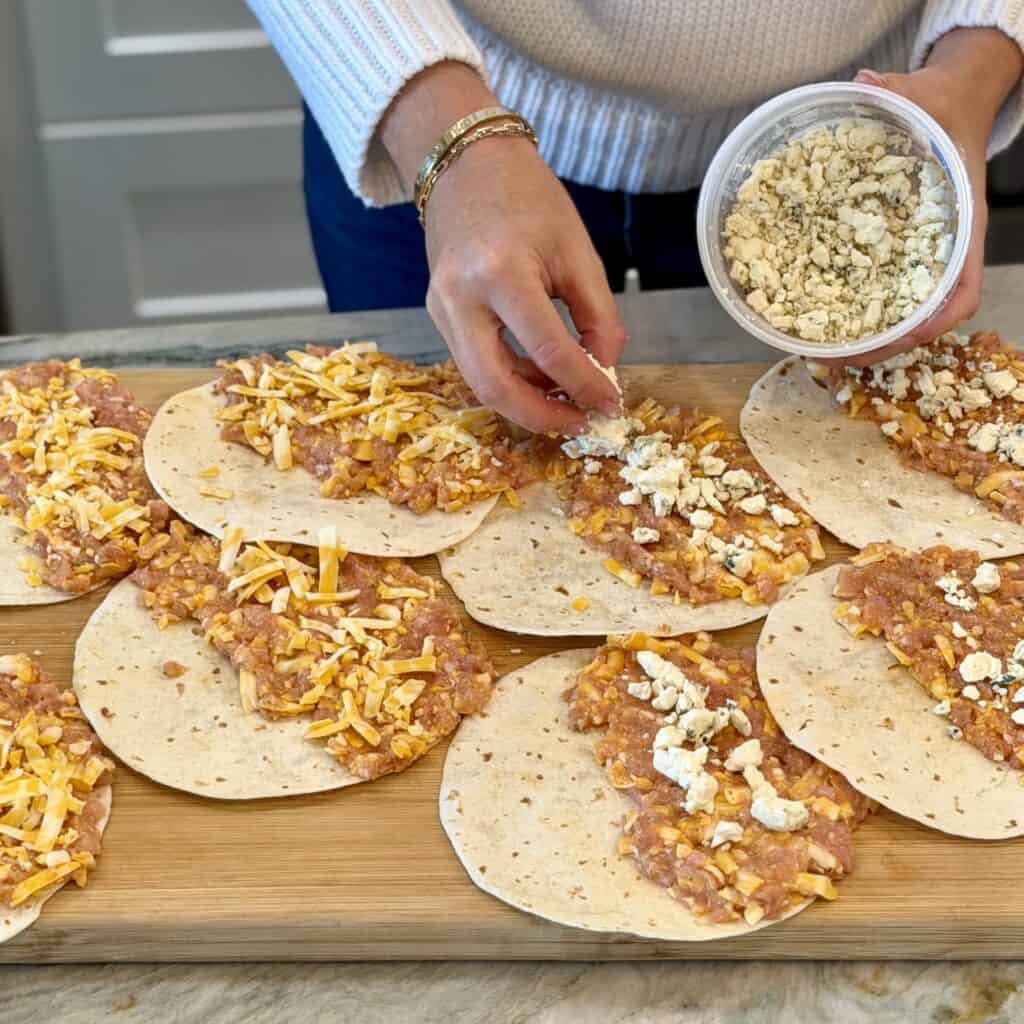 Adding cheese to the tacos.