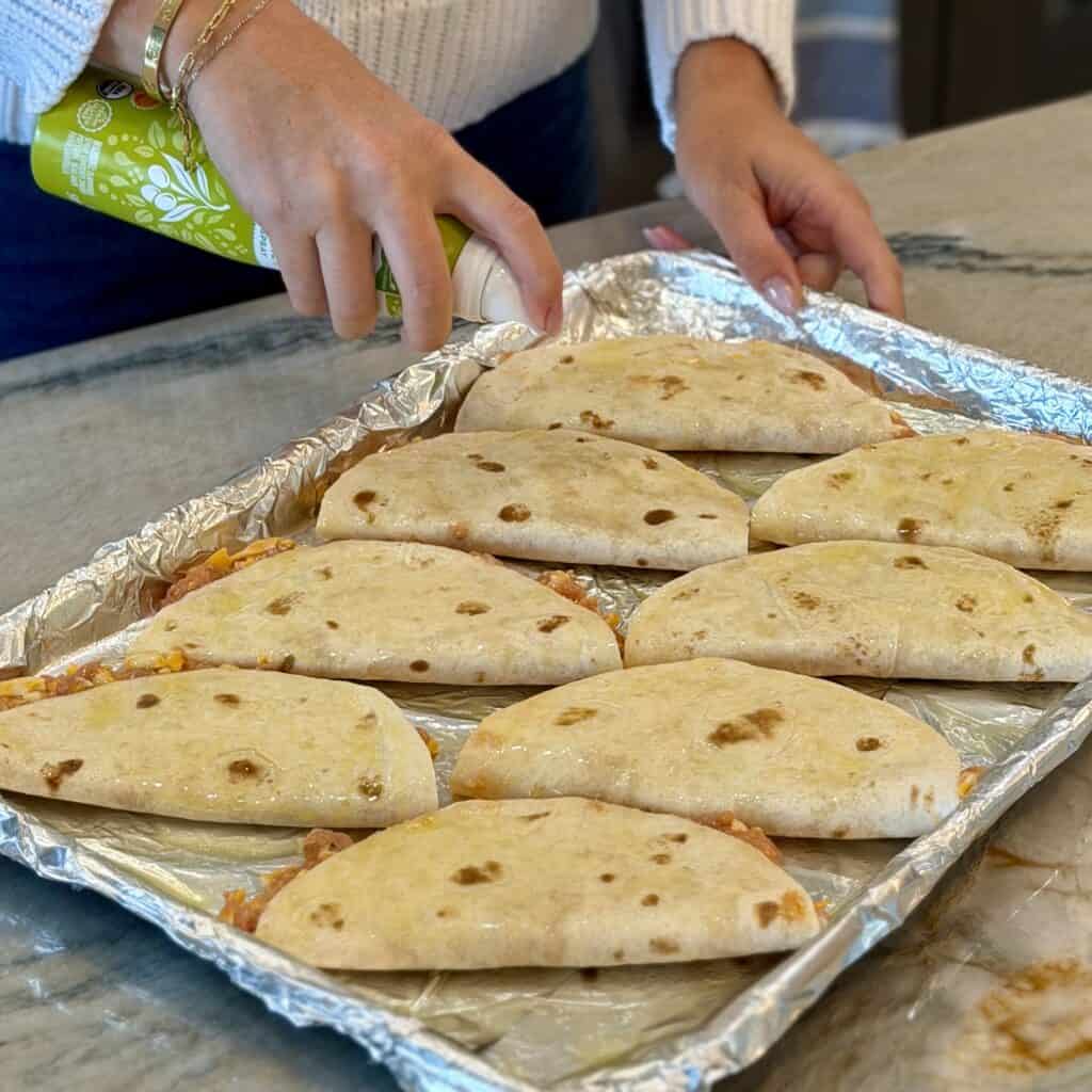 Spraying the sheet pan tacos.