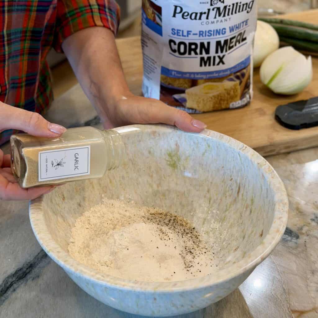 Adding garlic powder to the bowl.