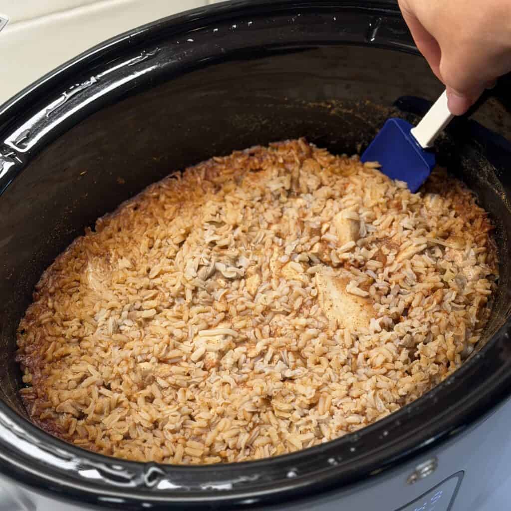 Mixing the chicken and rice.