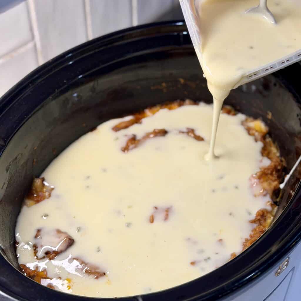 Adding cream to the pot.