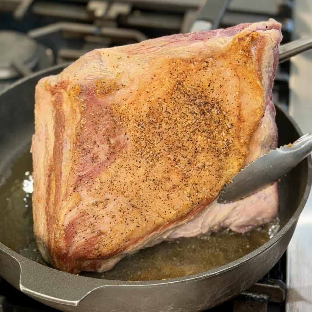 Flipping the roast in the pan.