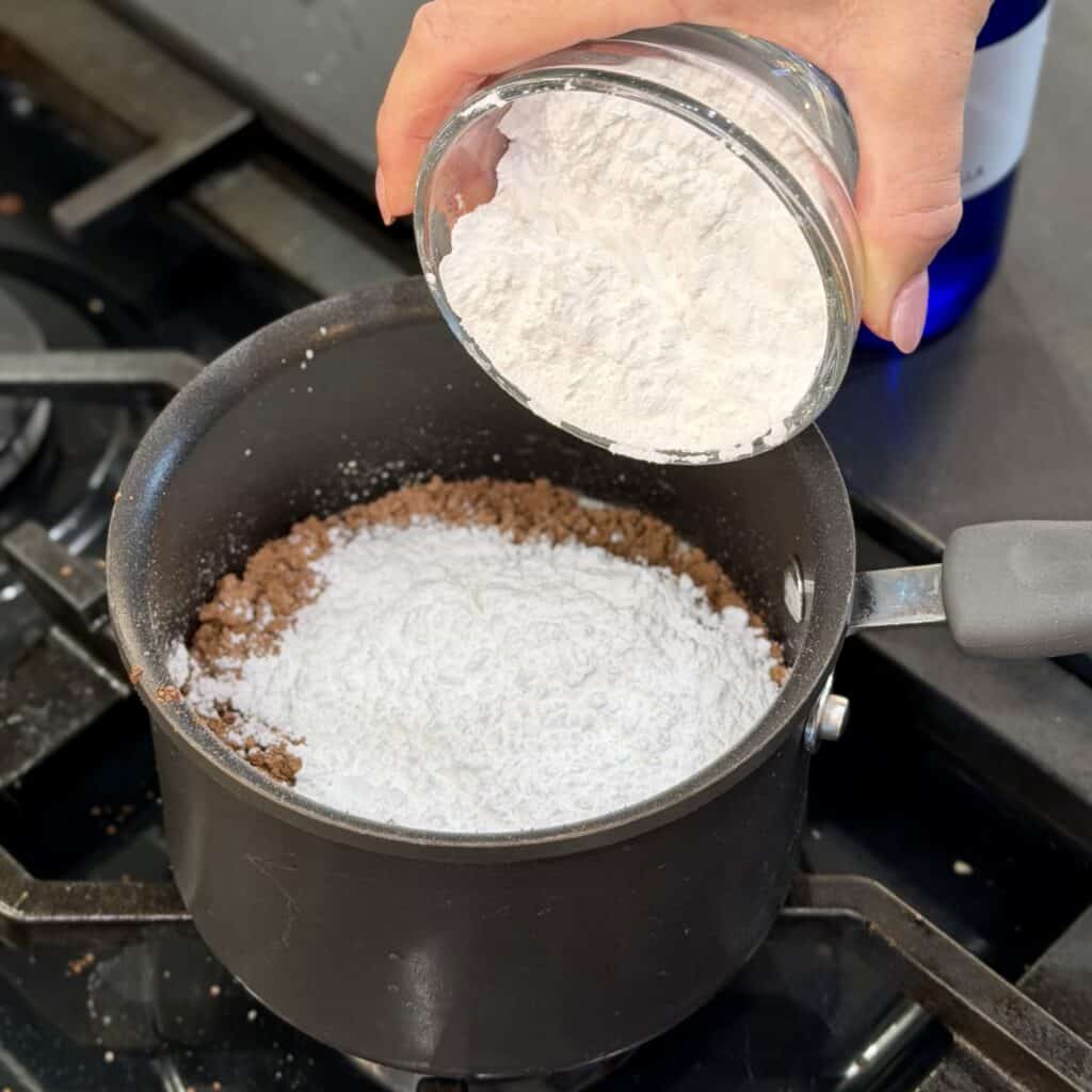 Stirring powdered sugar to the sauce pan.