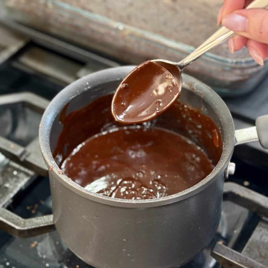 Stirring chocolate sauce in a saucepan.