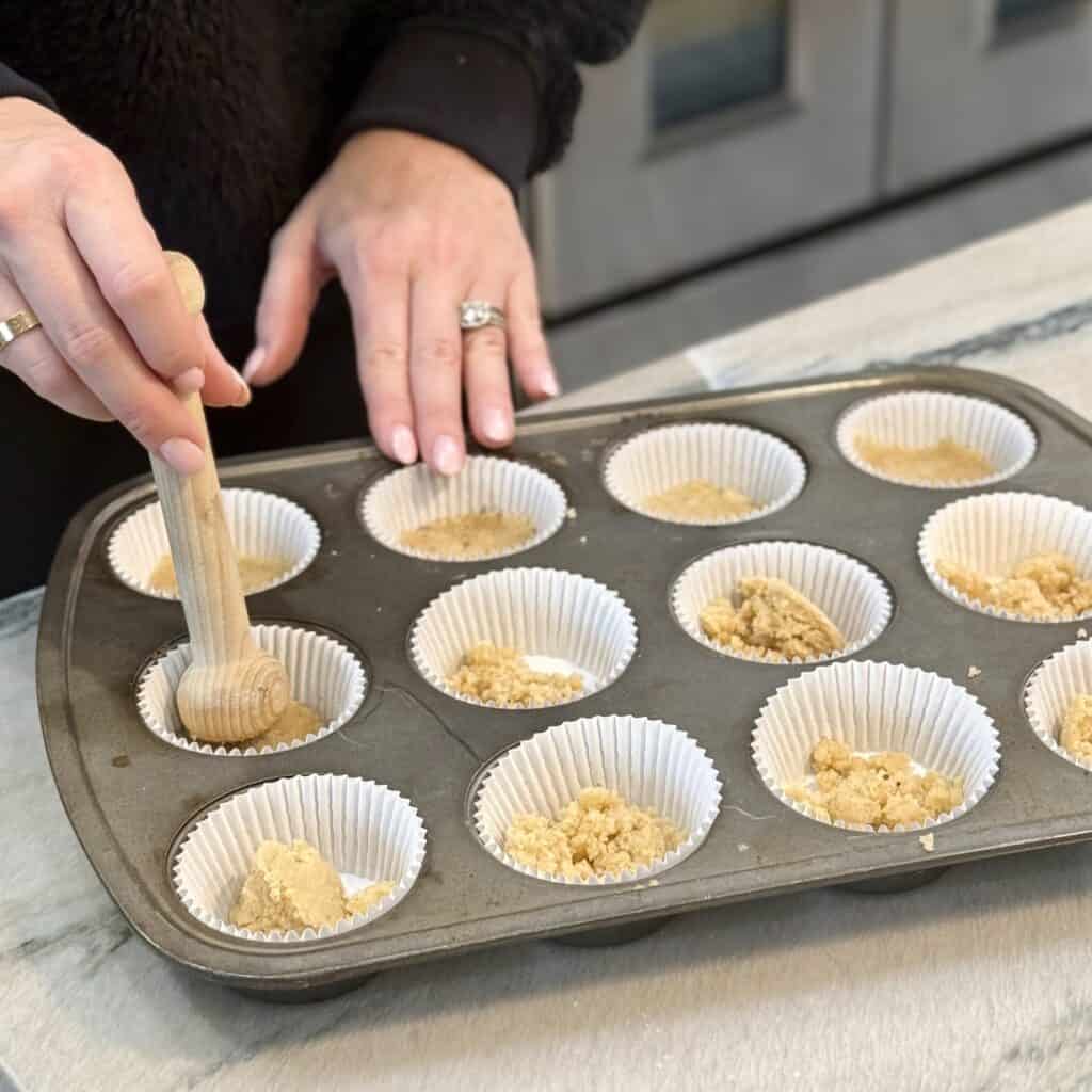 Stamping the cookies into the cupcake holders.