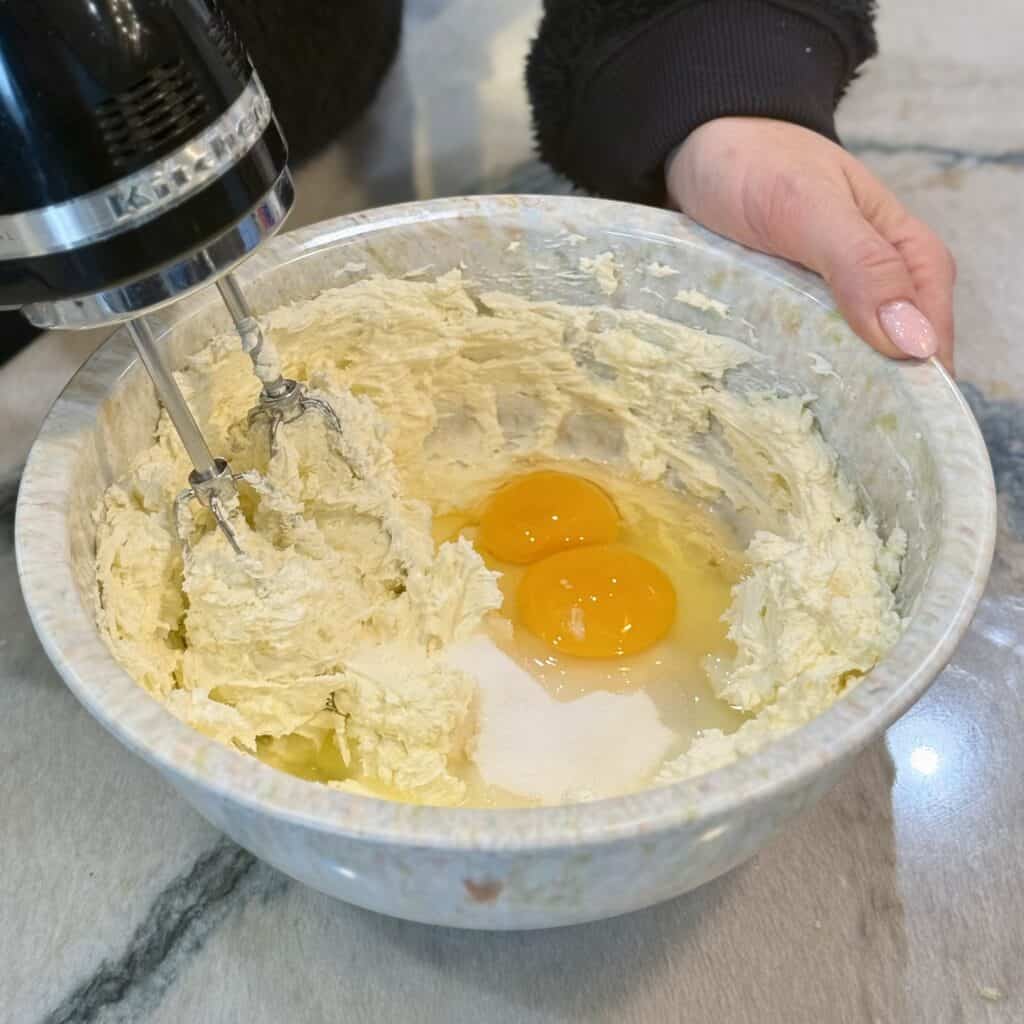 Adding eggs into the bowl.