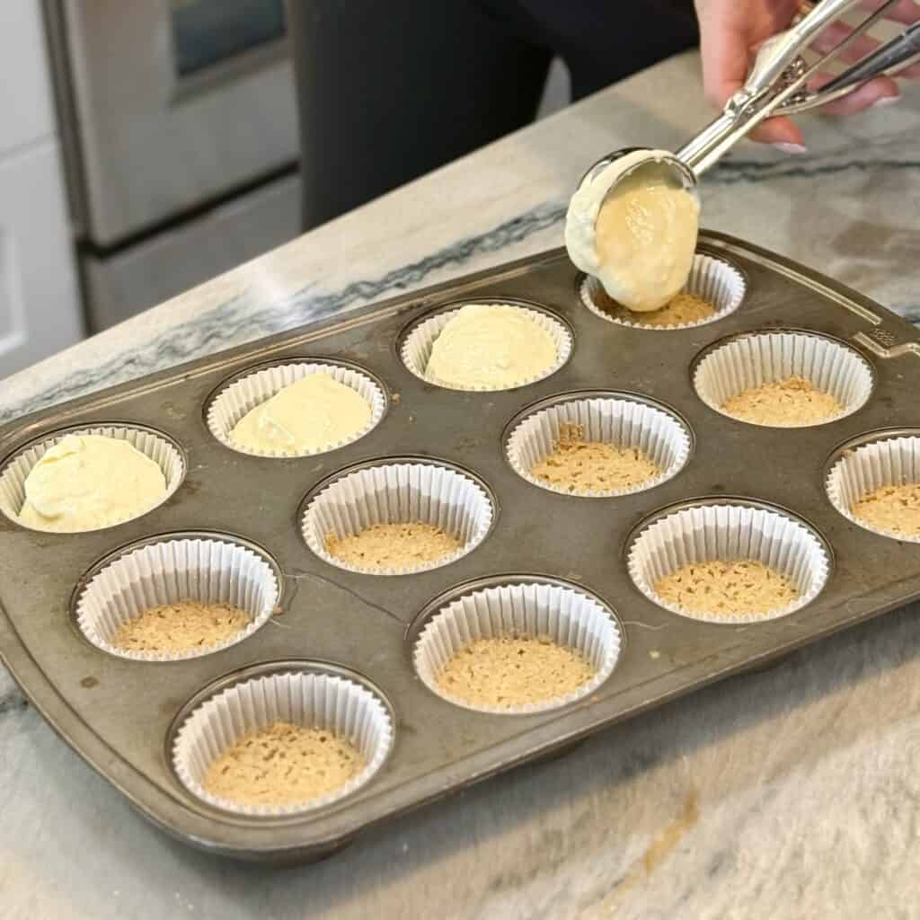 Adding the batter mixture into the cupcake holders.