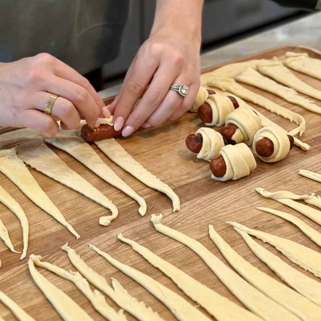 Wrapping sausages in the dough.