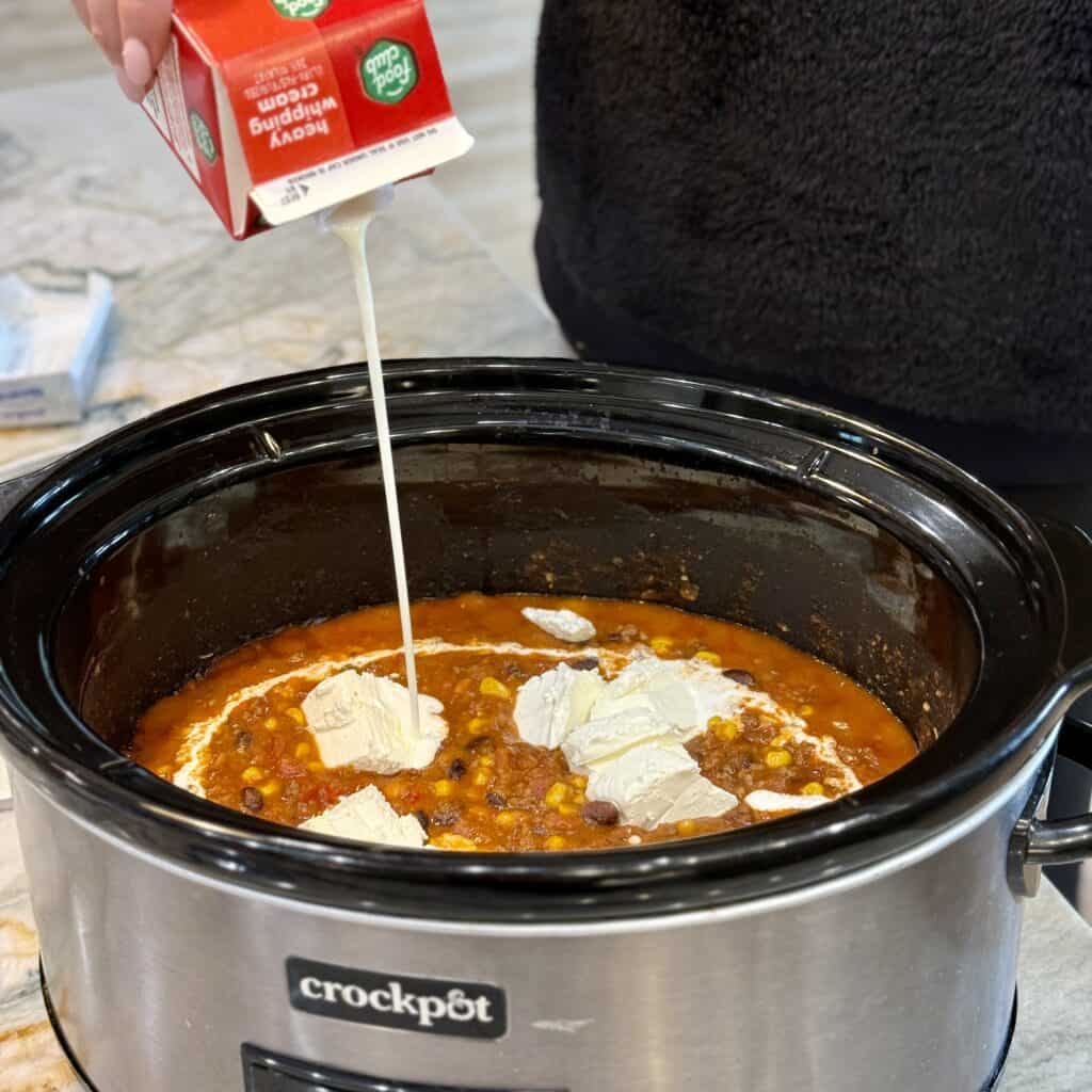 Adding cream to the pot.